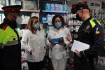 Two police officers inform a shop in Salou about the measures.